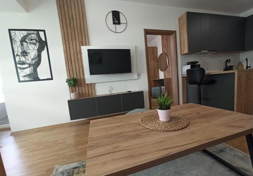 a living room with a table and a tv at Mango Apartments in Gevgelija