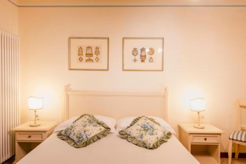 Capriva del FriuliにあるAppartamenti nelle Vigneのベッドルーム1室(白いベッド1台、ランプ2つ付)