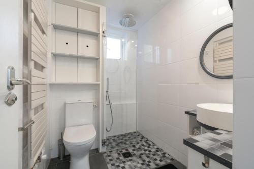 een witte badkamer met een toilet en een wastafel bij Duinland 110 - Sint Maartenszee in Sint Maartensvlotbrug