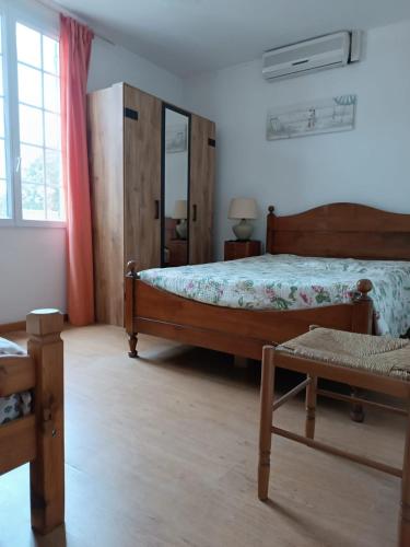 une chambre avec un grand lit et une fenêtre dans l'établissement Les Grillons, à Sainte-Maxime