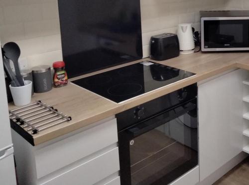 a kitchen with a stove top oven next to a microwave at Flat 1, 106 Belgrave Gate in Leicester