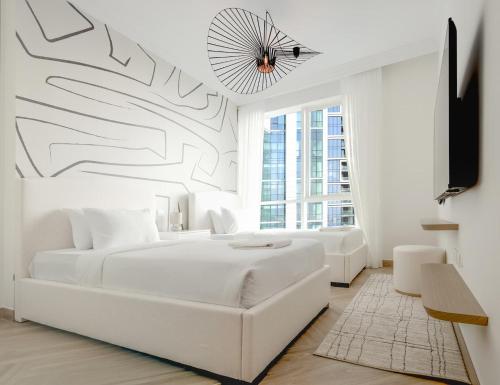 - une chambre blanche avec un lit blanc et une télévision dans l'établissement Sea View Condo With Private Beach! Big Terrace!, à Dubaï