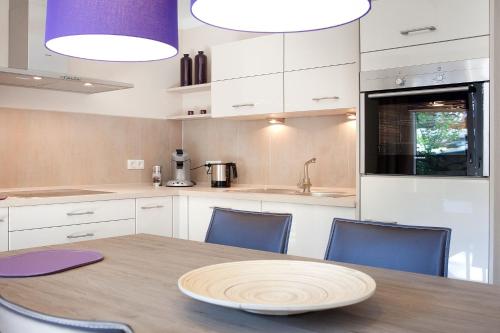 eine Küche mit einem Holztisch und blauen Stühlen in der Unterkunft die Strandhäuser - Leuchtfeuer in Ostseebad Sellin