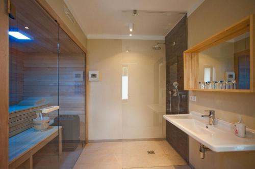 a bathroom with a glass shower and a sink at die Strandhäuser - Strandläufer in Ostseebad Sellin