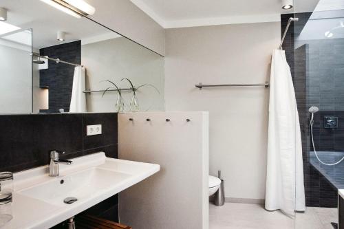 een witte badkamer met een wastafel en een douche bij die Strandhäuser - Strandläufer in Ostseebad Sellin