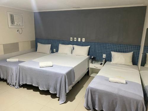 2 camas en una habitación con azulejos azules en Hotel Aliança, en Salvador