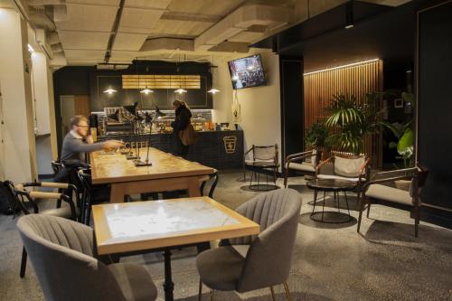a man sitting at a bar in a restaurant with tables and chairs at Letoh Letoh San Sebastián in Donostia-San Sebastián