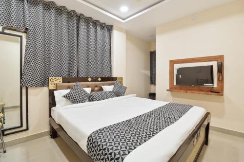 a bedroom with a large bed and a tv at HOTEL SANTHOSH DHABA SUITES-NEAR AIRPORT Zone in Shamshabad