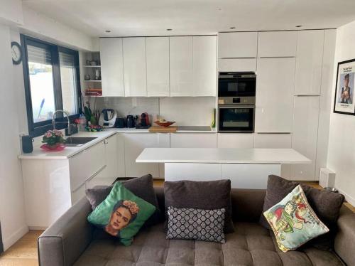 a living room with a couch and a kitchen at Luxury appartment 10 mn from Champs-Elysées in Neuilly-sur-Seine