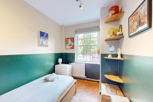 倫敦的住宿－3 bedroom Family Friendly Apartment in Hillcrest，卧室拥有绿色和白色的墙壁,配有一张床