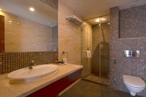 a bathroom with a sink and a shower and a toilet at Celesta - Kolkata in Kolkata