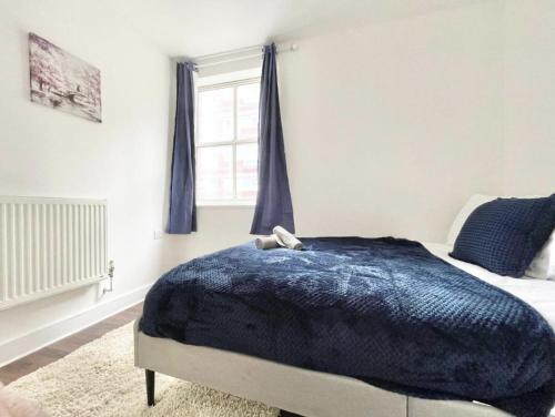 a bedroom with a bed with a blue blanket at Cozy Southampton Retreat: Free Parking for Contractors, Families, and Tourists in Southampton