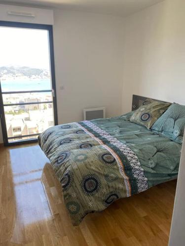 une chambre avec un lit et une grande fenêtre dans l'établissement Superbe appartement sur les hauteurs d’Ajaccio, à Ajaccio