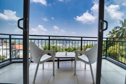 a balcony with a table and chairs and a view at Amandara Hills Kandy in Kandy
