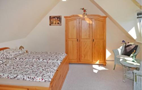 - une chambre avec un lit et une armoire en bois dans l'établissement Cozy Home In Stolpe-usedom With Wifi, à Stolpe auf Usedom