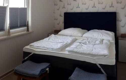 a bed with white sheets and pillows in a room at Beautiful Apartment In Graal-mritz ostseehe With Kitchen in Müritz