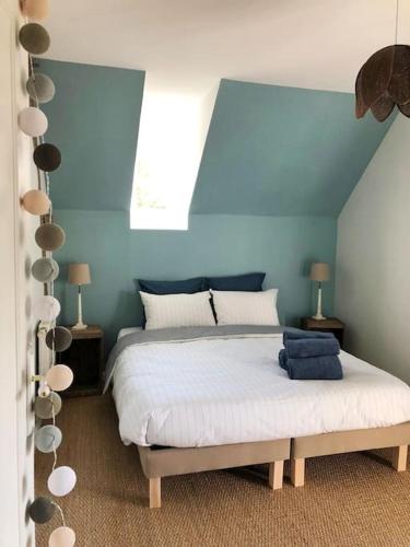 1 dormitorio con 1 cama grande y pared azul en Gîte Les Caves aux Fièvres - Maison avec jardin près de Chinon, en Beaumont-en-Véron
