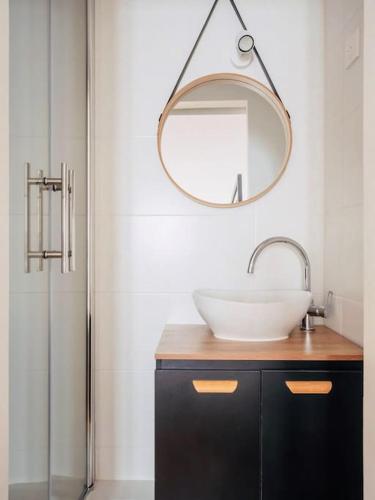 une salle de bain avec un lavabo, un miroir et une douche dans l'établissement Maison au cœur du Vieux-Port de La Rochelle, à La Rochelle