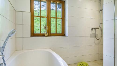 a white bath tub in a bathroom with a window at Schlegelhansenhof in Buchenbach