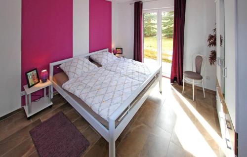 a bedroom with a white bed and a purple wall at Stunning Home In Funkenhagen With Sauna in Funkenhagen