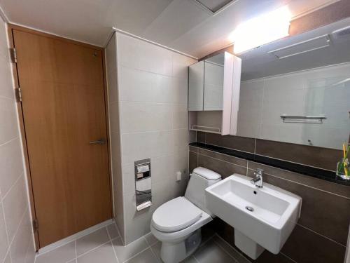 ein Badezimmer mit einem weißen WC und einem Waschbecken in der Unterkunft Party Room, 1min to Suwon Rodeo Street in Suwon