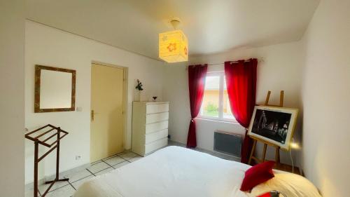a bedroom with a bed and a window with red curtains at « La Cigale » in Peyruis