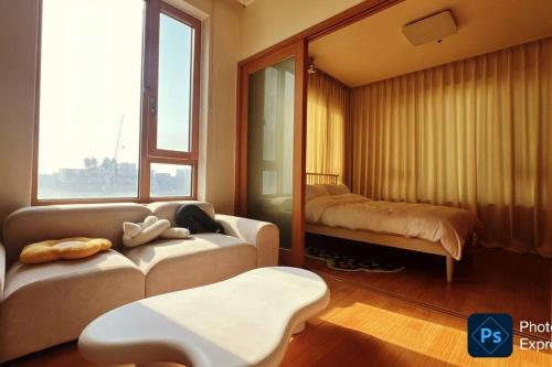 a living room with a couch and a bed at Party Room, 1min to Suwon Rodeo Street in Suwon
