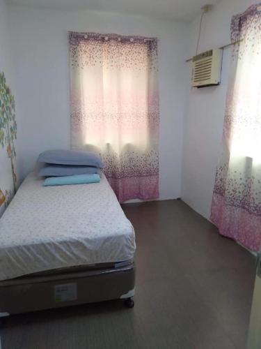 ein kleines Schlafzimmer mit einem Bett und einem Fenster in der Unterkunft Al Manzil in General Santos