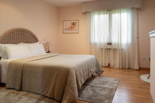 Un dormitorio con una cama grande y una ventana en Motel Bambú, en Lugo