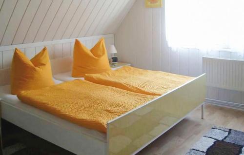 1 cama con sábanas y almohadas amarillas en un dormitorio en 2 Bedroom Pet Friendly Home In Plau Am See, en Plau am See