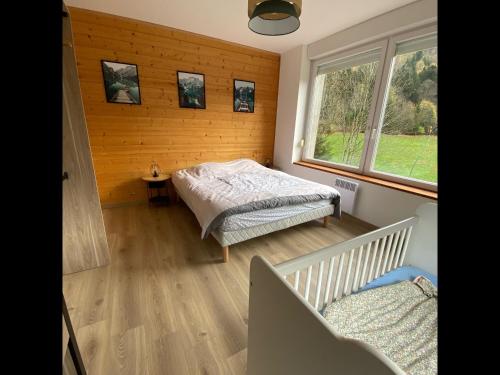 um quarto com uma cama e duas janelas em La Perle de Xonrupt - Appt vue montagne em Xonrupt-Longemer
