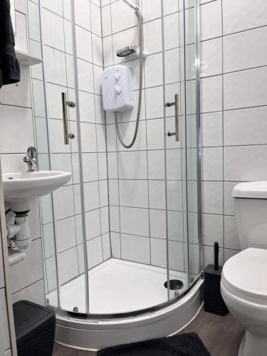 a bathroom with a shower with a toilet and a sink at Meadow Street Rooms in Avonmouth