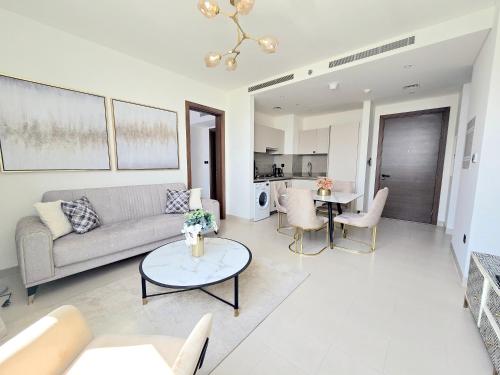 a living room with a couch and a table at Sleek and Stylish 2-Bedroom Apartment in Dubai