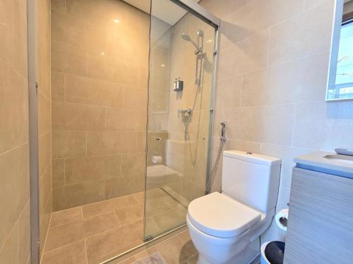 a bathroom with a toilet and a glass shower at Sleek and Stylish 2-Bedroom Apartment in Dubai