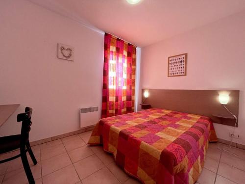 1 dormitorio con 1 cama con una manta colorida en Appartement Gruissan, 2 pièces, 4 personnes - FR-1-229-372, en Gruissan