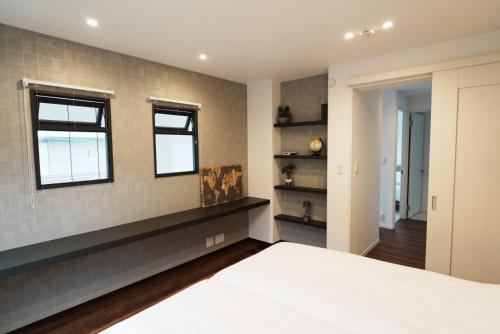 um quarto com uma cama e duas janelas em Akikawa Villas 1 em Yuge