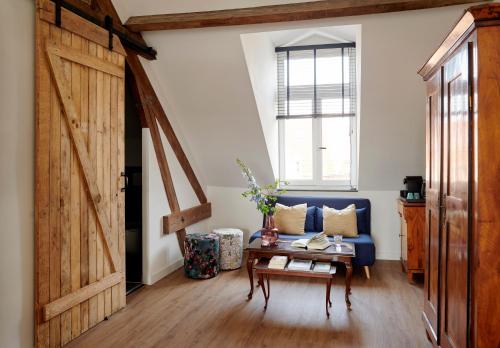 a living room with a blue couch and a table at La Dominotte Arcen in Arcen