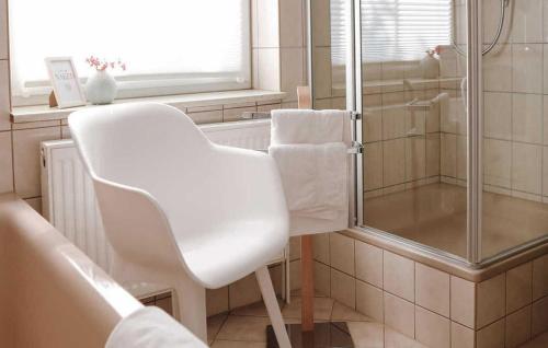 a white chair in a bathroom with a shower at Lovely Home In Boitzenburger Land With Kitchen in Haßleben