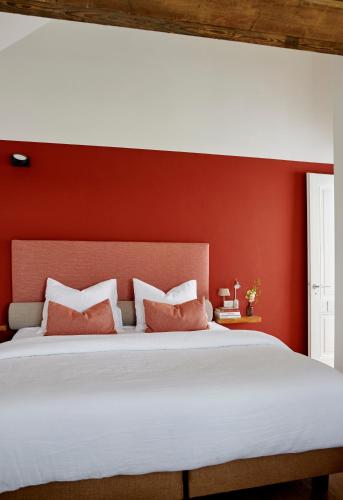 a bedroom with red walls and a bed with pillows at La Dominotte Arcen in Arcen