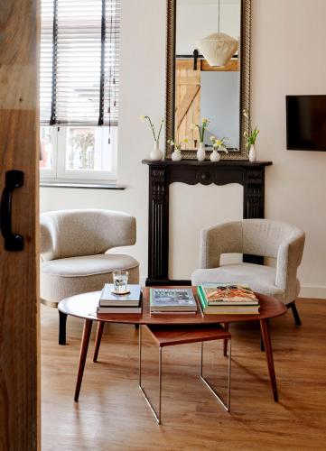 a living room with a coffee table and two chairs at La Dominotte Arcen in Arcen