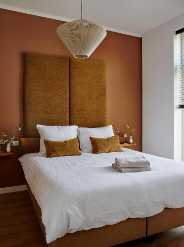 a bedroom with a large bed with white sheets at La Dominotte Arcen in Arcen