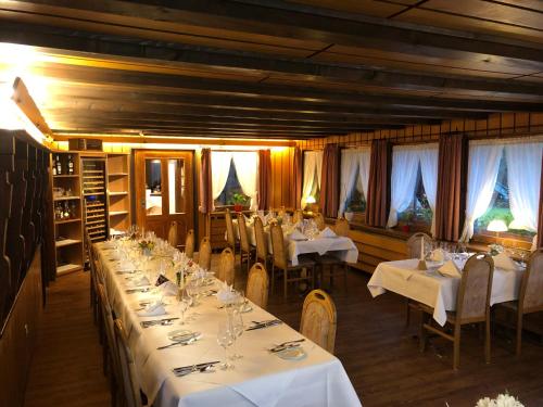 托特莫斯的住宿－Das Schwarzwaldhotel，一间设有白色桌椅和窗户的用餐室