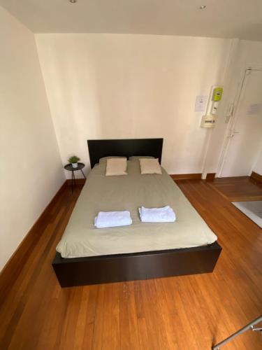 een slaapkamer met een bed met twee handdoeken erop bij Studio Proche Paris in Chaville