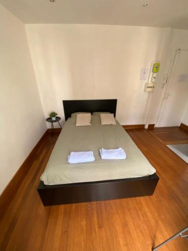 Un dormitorio con una cama con dos toallas encima. en Studio Proche Paris, en Chaville