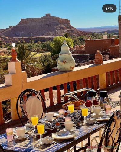 einen Tisch mit Gläsern Orangensaft und Bergblick in der Unterkunft L'oasis Du Bonheur in Aït-Ben-Haddou