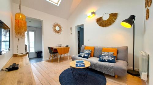a living room with a couch and a table at Les Appartements du 104 in Saint-Jean-de-Monts