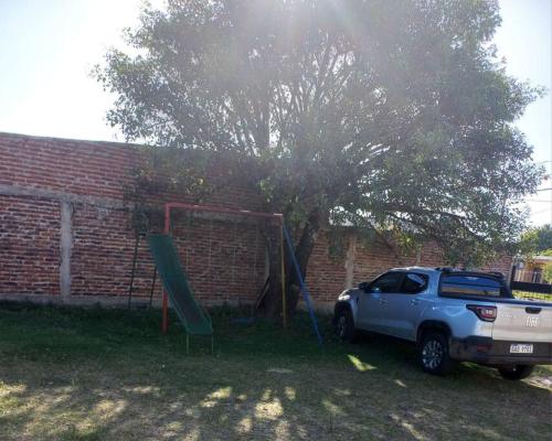 un camion parcheggiato accanto a un albero e un parco giochi di Casa amplia y bien ubicada a Artigas