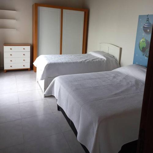 a bedroom with two beds and a dresser at Casa amplia y bien ubicada in Artigas
