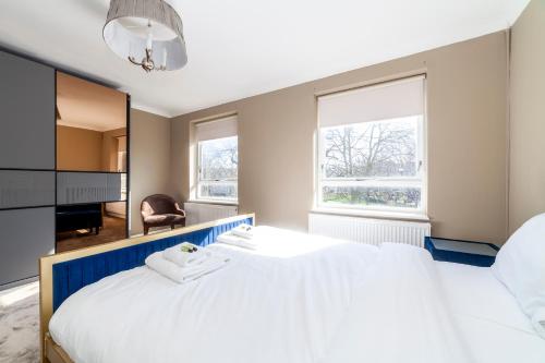 a bedroom with a large white bed and a desk at Wonderful 5 BDR Flat wParking, Maida Vale in London