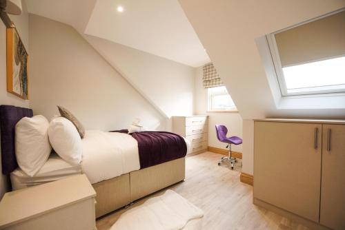 a attic bedroom with a bed and a window at Elm House in Reading